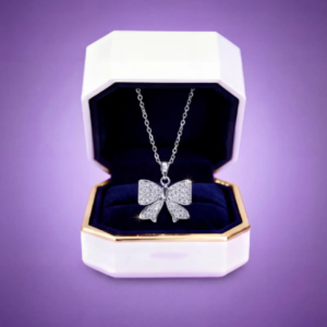 Silver bow necklace with sparkling stones displayed in an elegant jewelry gift box.