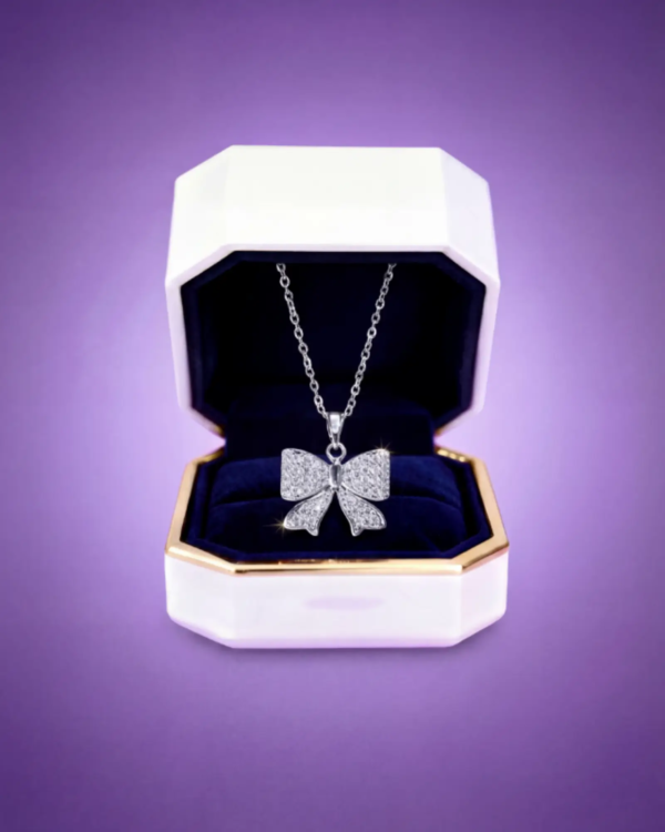 Silver bow necklace with sparkling stones displayed in an elegant jewelry gift box.