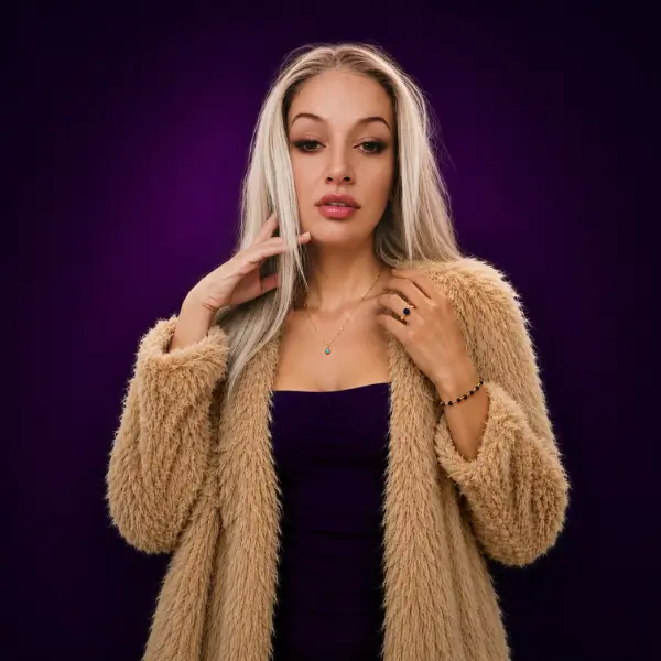 Andreea wearing gemstone jewelry from the Luxe Éternelle collection including a sapphire ring, black onyx bracelet, and blue chalcedony necklace