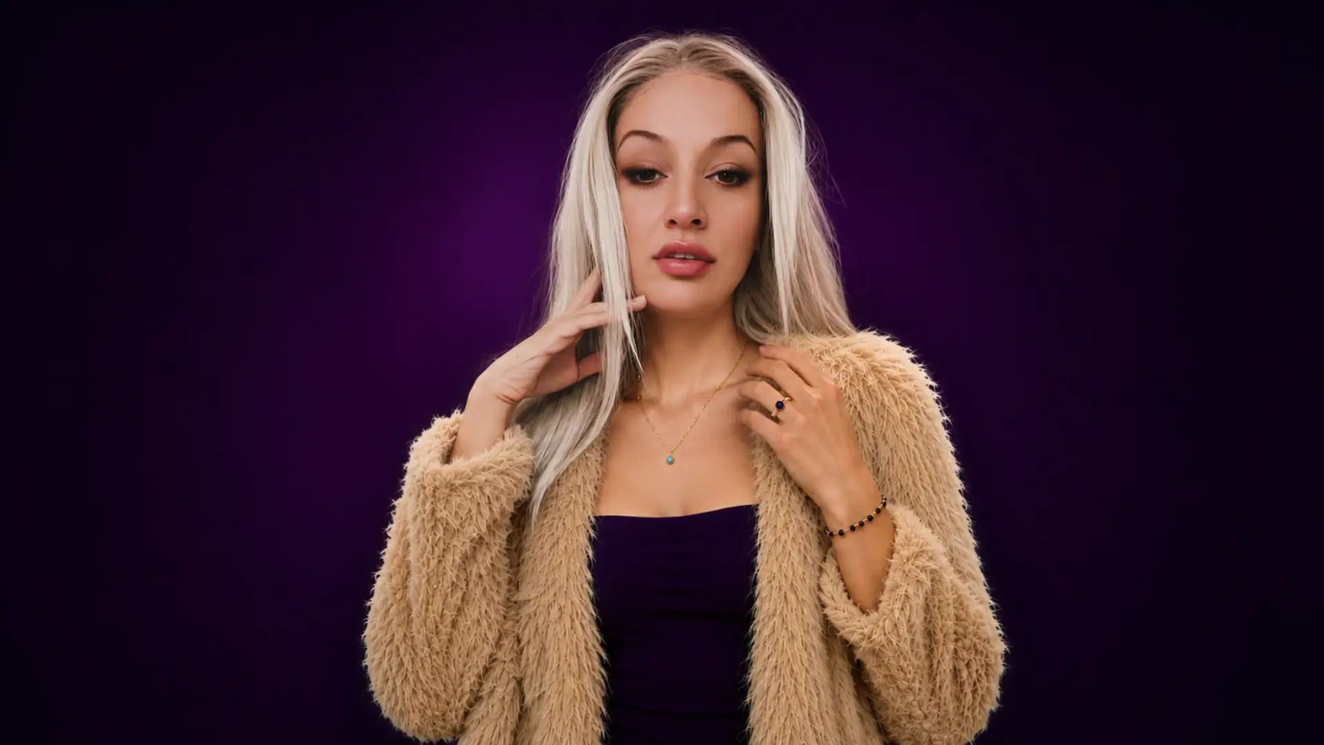 Andreea wearing gemstone jewelry from the Luxe Éternelle collection including a sapphire ring, black onyx bracelet, and blue topaz necklace and earrings