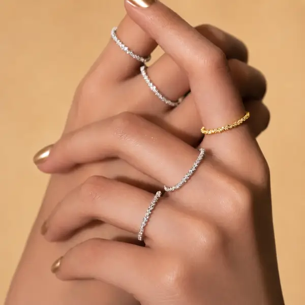 Silver and gold vermeil stackable rings worn together on model's hand, showing layered ring pairing
