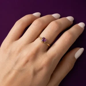 Gold amethyst and diamond engagement ring worn on finger, close-up